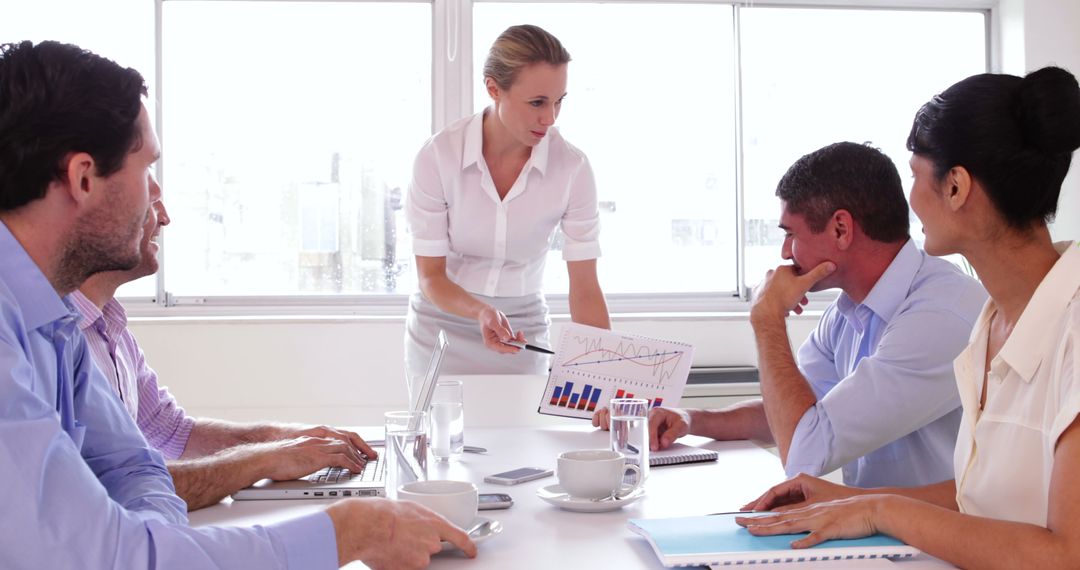 Group of Business Professionals Reviewing Chart Data in Office Meeting - Free Images, Stock Photos and Pictures on Pikwizard.com