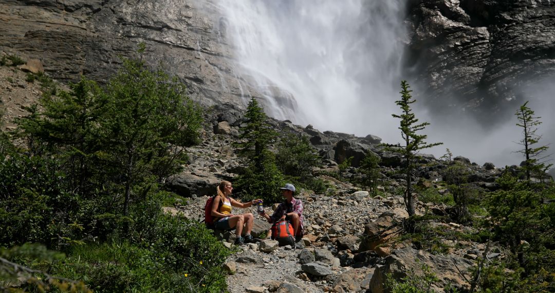 Hikers Resting Near Waterfall in Mountainous Landscape - Free Images, Stock Photos and Pictures on Pikwizard.com