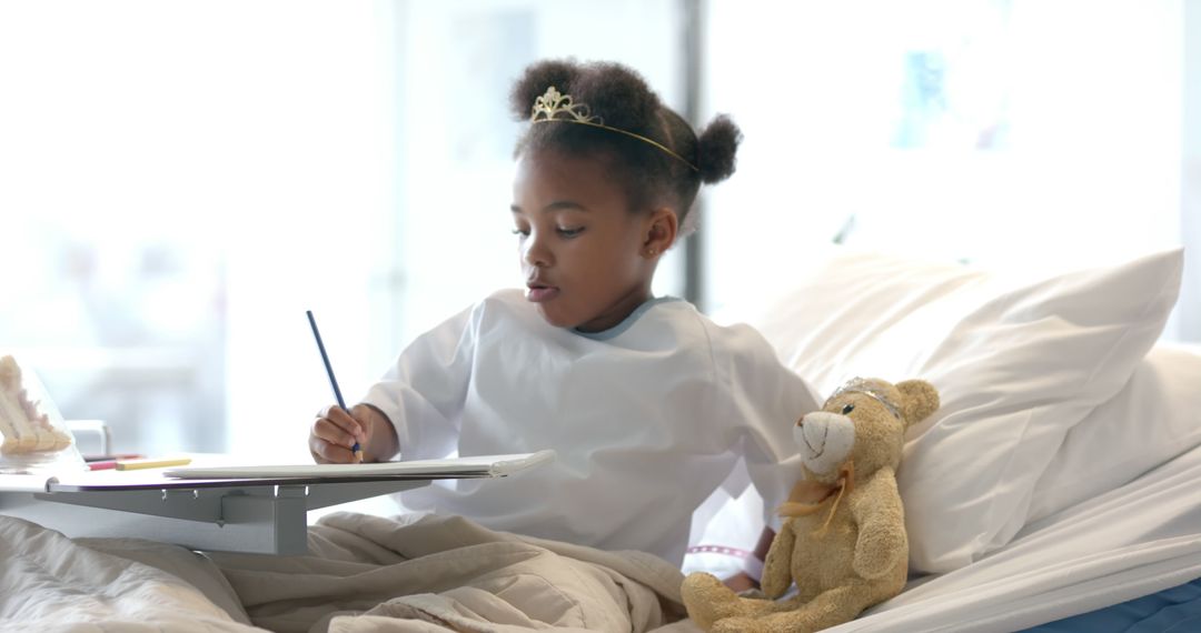 Young Girl Writing in Hospital Bed with Teddy Bear - Free Images, Stock Photos and Pictures on Pikwizard.com