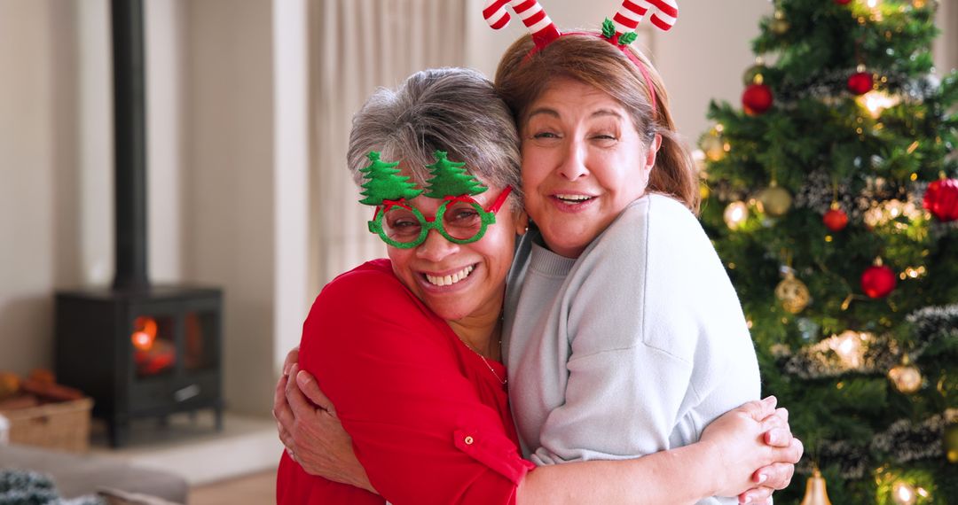 Joyful Mother and Daughter Hugging by Christmas Tree