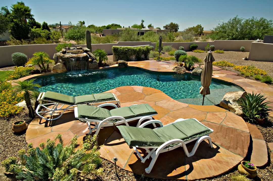 Scenic Backyard Swimming Pool with Waterfall and Lounge Chairs - Free Images, Stock Photos and Pictures on Pikwizard.com