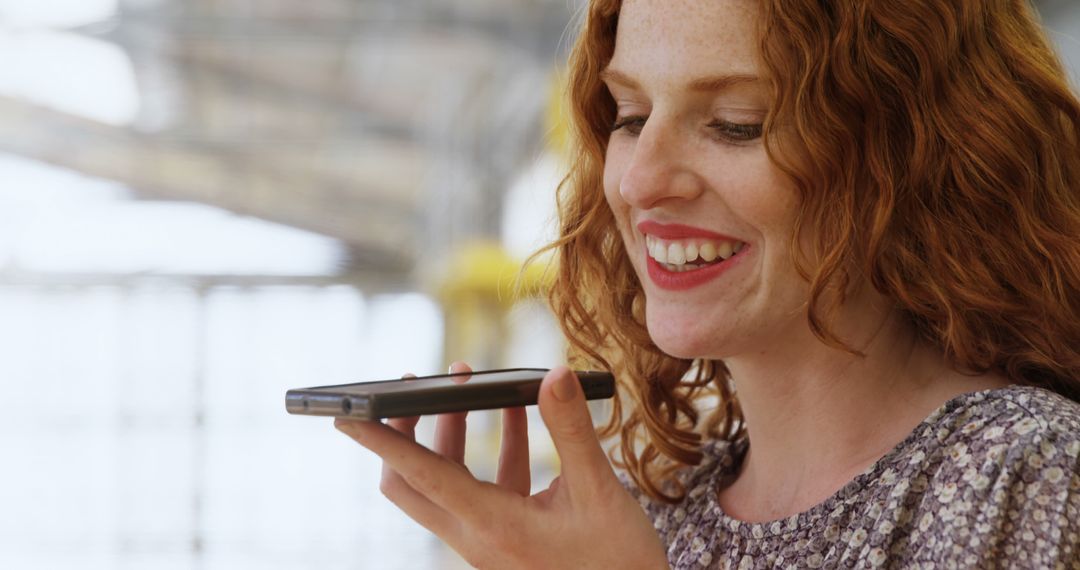 Woman with Red Hair Using Smartphone for Voice Message near Window - Free Images, Stock Photos and Pictures on Pikwizard.com