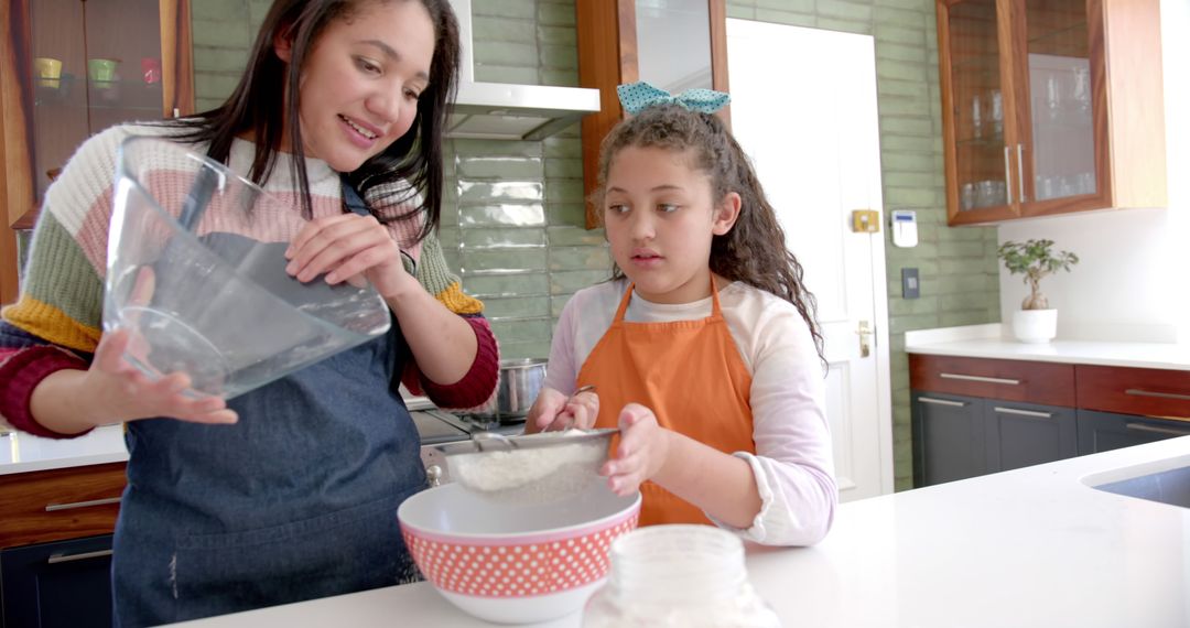 Smiling Biracial Mother and Daughter Baking Together in Sunlit Kitchen - Free Images, Stock Photos and Pictures on Pikwizard.com