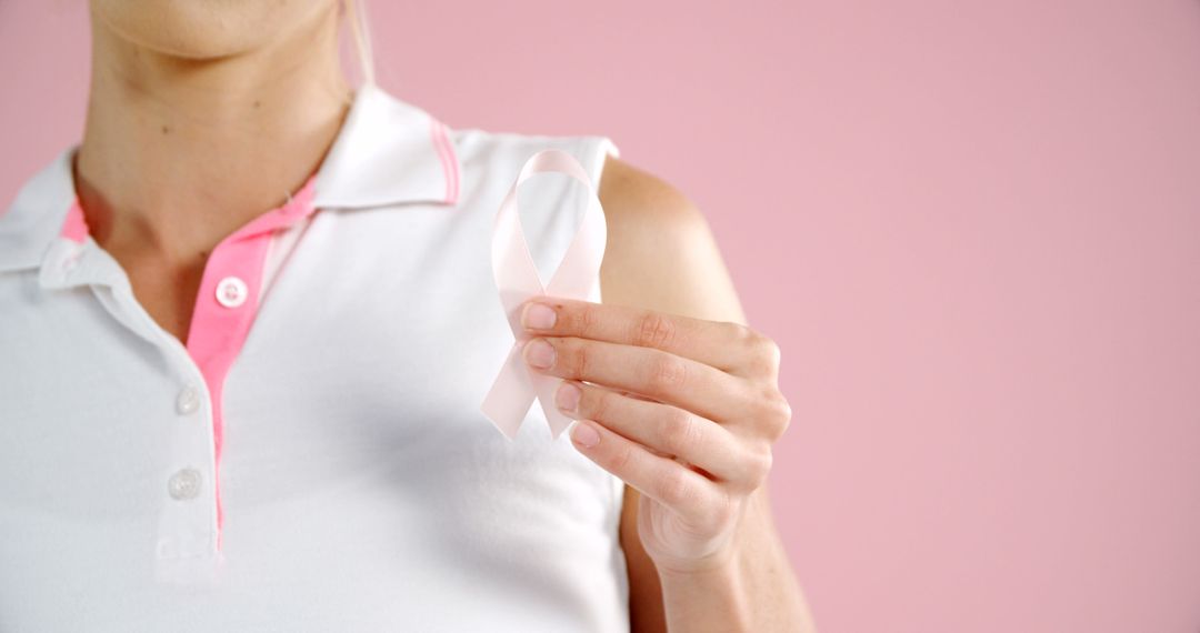 Woman Holding Breast Cancer Awareness Ribbon on Pink Background - Free Images, Stock Photos and Pictures on Pikwizard.com