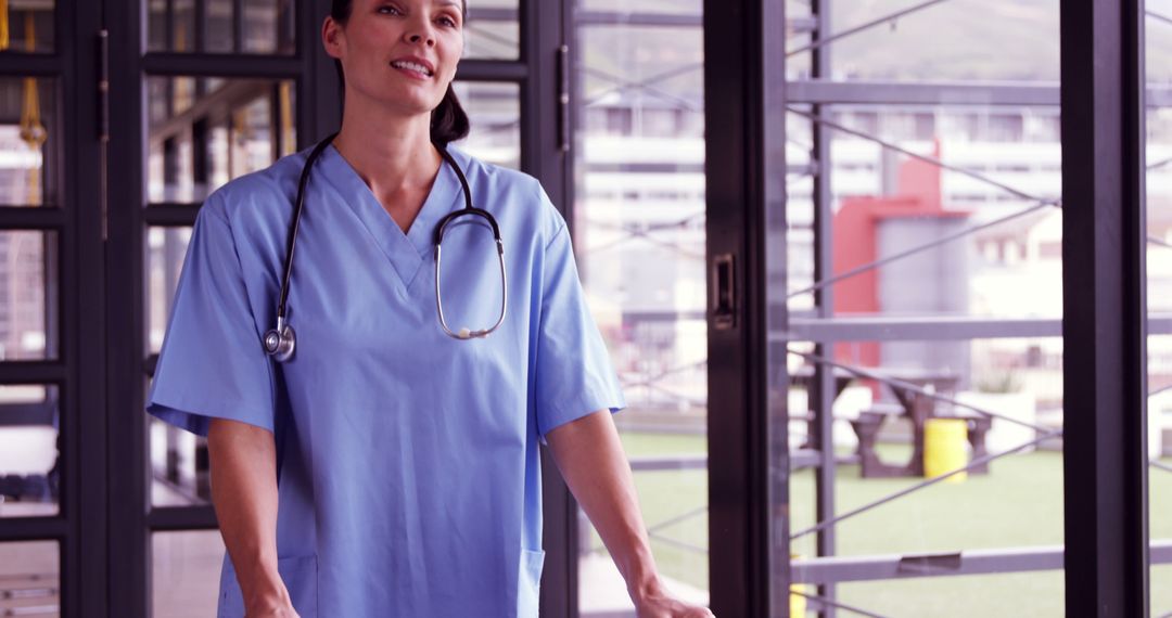 Confident Nurse in Blue Scrubs Standing in Modern Hospital - Free Images, Stock Photos and Pictures on Pikwizard.com