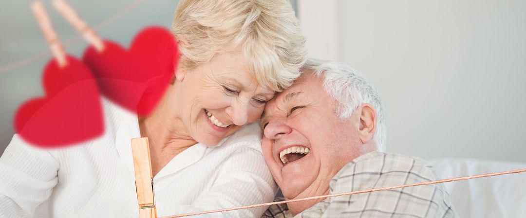 Joyful elderly couple sharing affectionate moment with heart decor