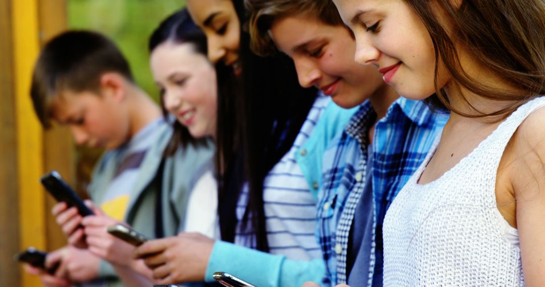 Teens Using Smartphones in Park, Smiling and Engaged - Free Images, Stock Photos and Pictures on Pikwizard.com