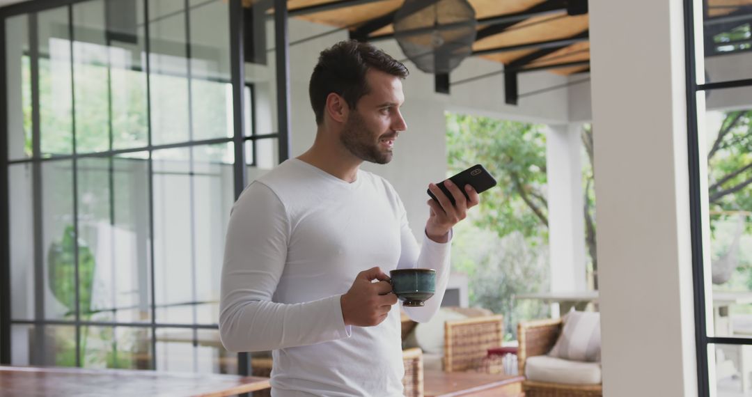 Man Drinking Coffee and Talking on Phone in Modern Home - Free Images, Stock Photos and Pictures on Pikwizard.com