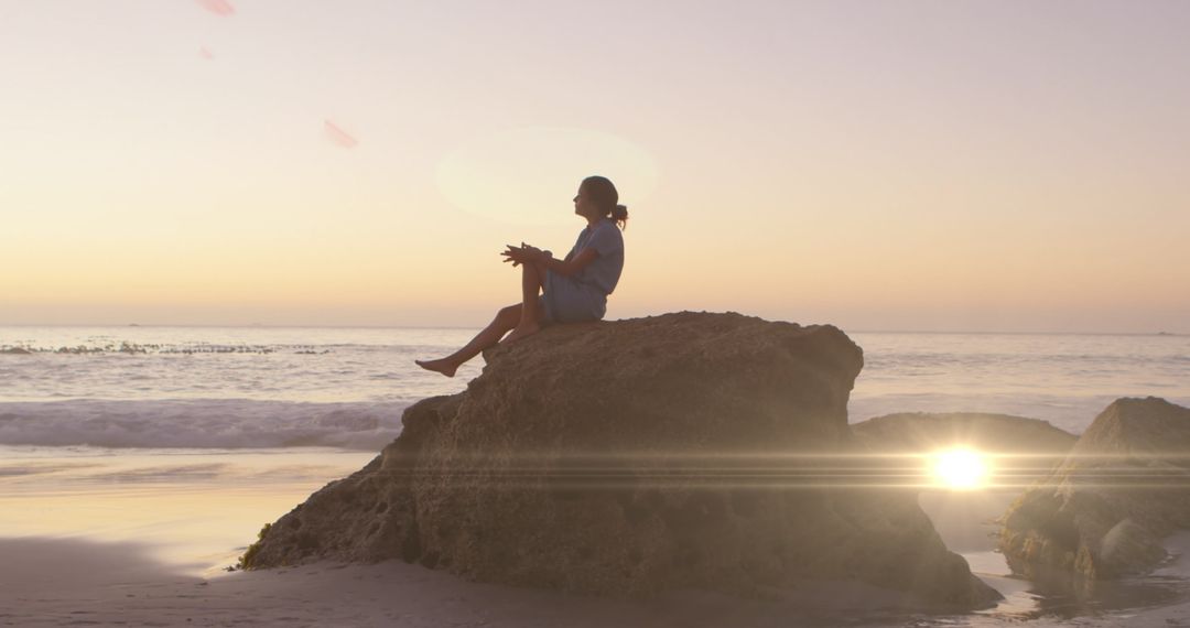 Woman Reflecting During Sunset Beach Scene with Lens Flare