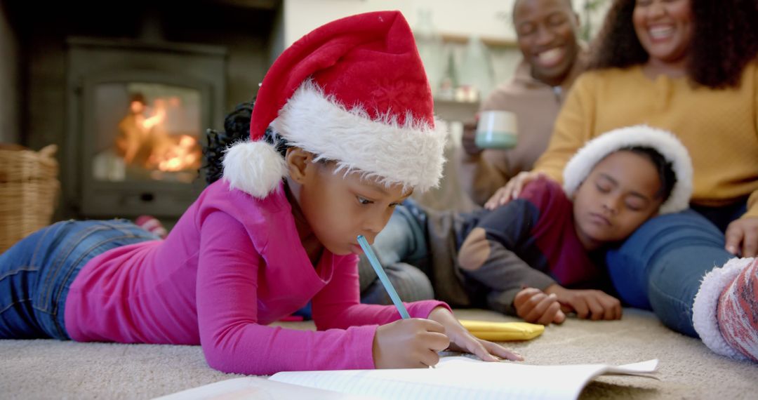 Young girl drawing with Christmas hat in cozy living room - Free Images, Stock Photos and Pictures on Pikwizard.com