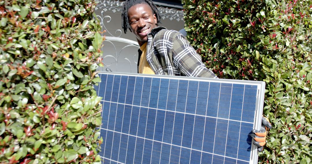 Smiling Person Carrying Solar Panel in Garden - Free Images, Stock Photos and Pictures on Pikwizard.com