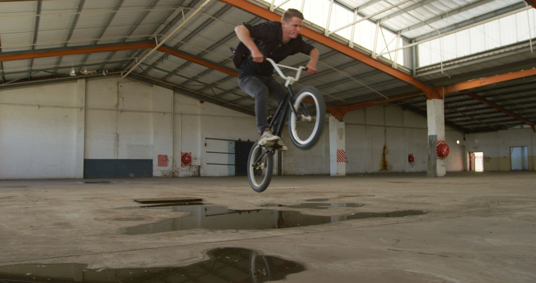 BMX Rider Performing Trick in Abandoned Warehouse - Free Images, Stock Photos and Pictures on Pikwizard.com