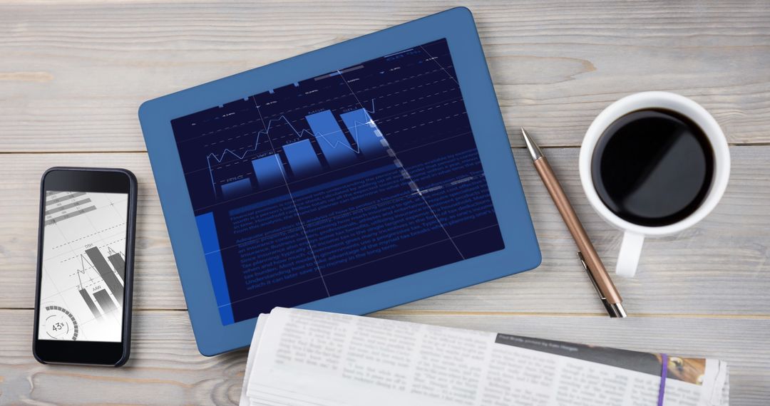 Table with Digital Devices Showing Financial Data and Coffee