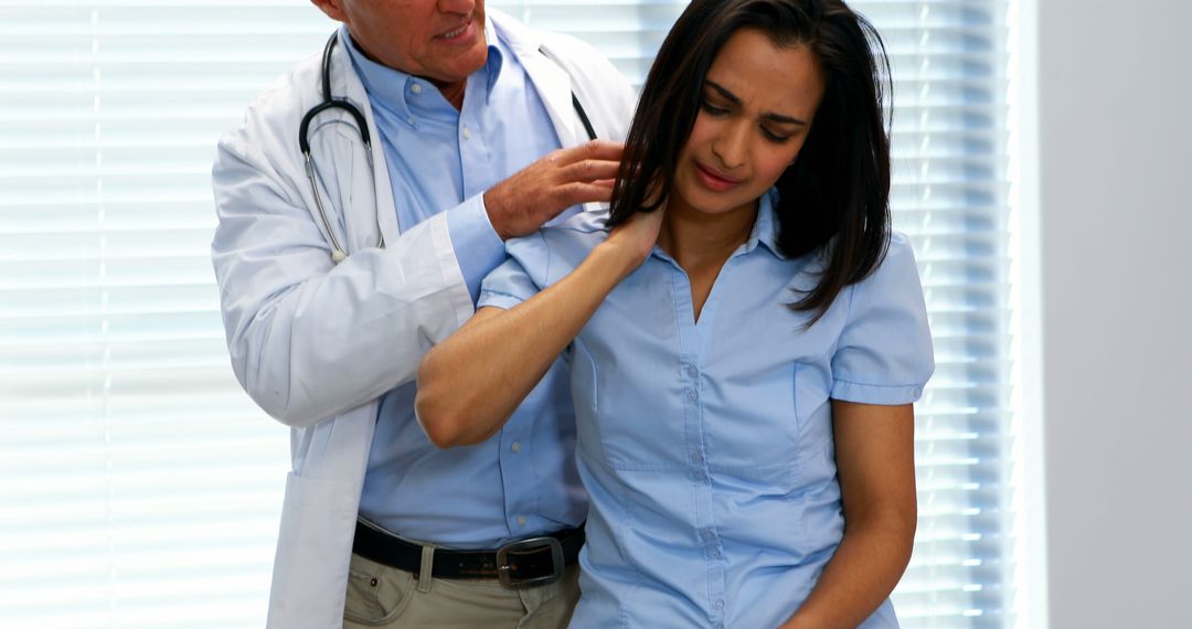 Female Patient Experiencing Shoulder Pain with Doctor Examination - Free Images, Stock Photos and Pictures on Pikwizard.com