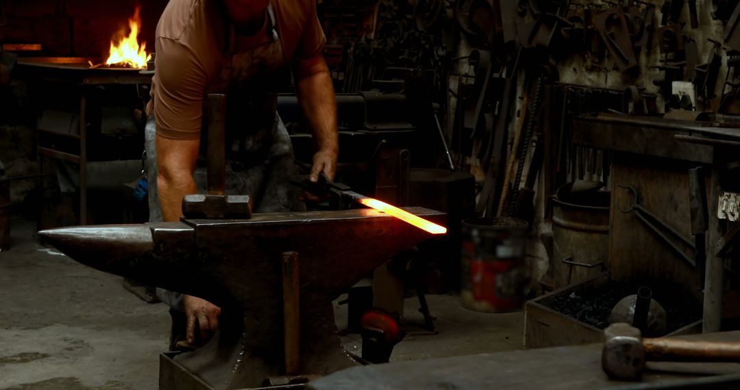 Blacksmith forging heated iron on anvil in traditional workshop - Free Images, Stock Photos and Pictures on Pikwizard.com