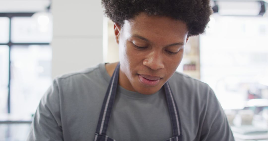 Young African American chef focused while cooking in kitchen - Free Images, Stock Photos and Pictures on Pikwizard.com