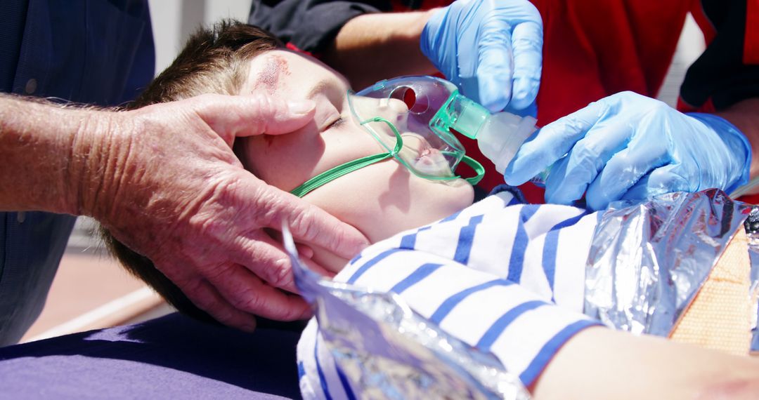 Emergency Responders Treating Child with Oxygen Mask Outdoors - Free Images, Stock Photos and Pictures on Pikwizard.com