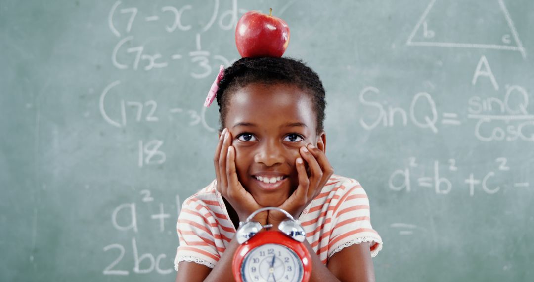 Smiling Girl Balancing Apple on Head in Classroom - Free Images, Stock Photos and Pictures on Pikwizard.com