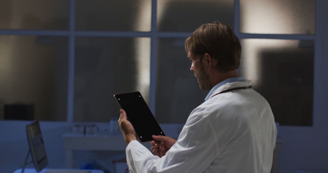 Male Doctor Using Tablet in Modern Medical Office at Night - Free Images, Stock Photos and Pictures on Pikwizard.com