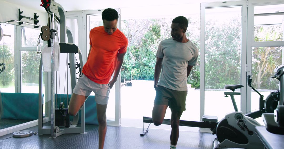 Two Men Practicing Stretching Exercises in a Gym Setting