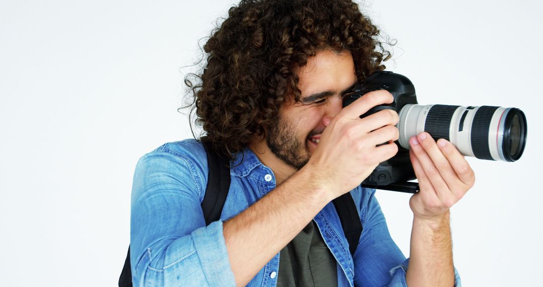 Young Male Photographer Focusing Through Camera Lens in Studio - Free Images, Stock Photos and Pictures on Pikwizard.com