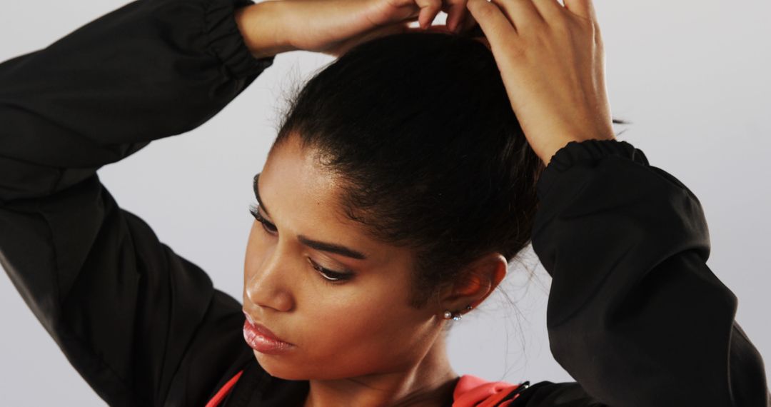 Woman Tying Her Hair in Activewear - Free Images, Stock Photos and Pictures on Pikwizard.com