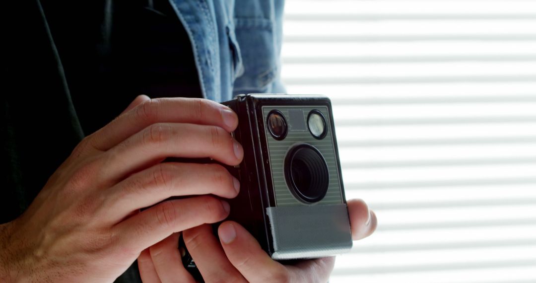 A person is holding a vintage camera, ready to take a photograph, with copy space - Free Images, Stock Photos and Pictures on Pikwizard.com