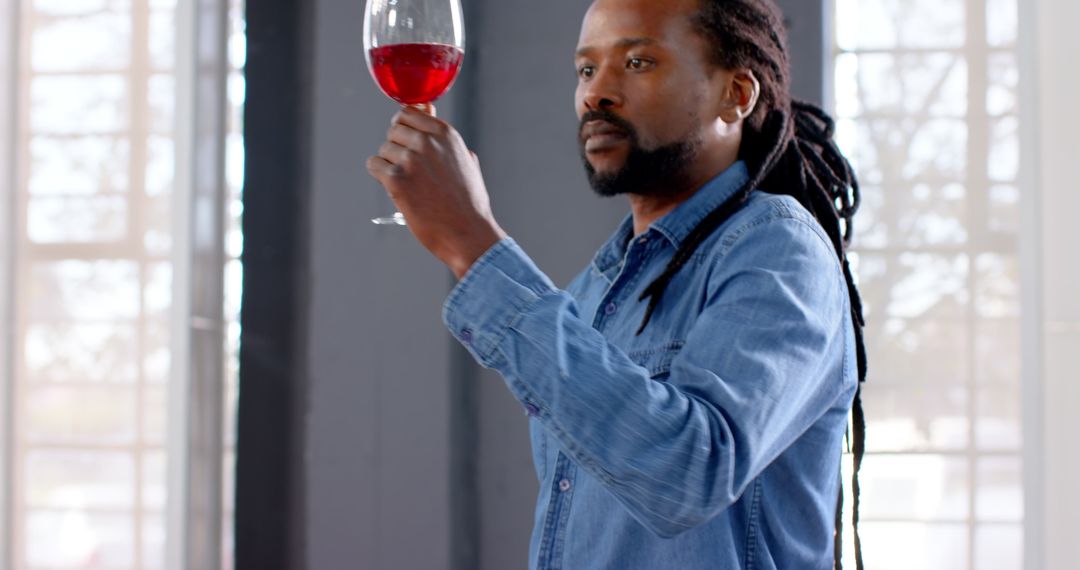 Sommelier Analyzing Red Wine Indoors with Focused Expression