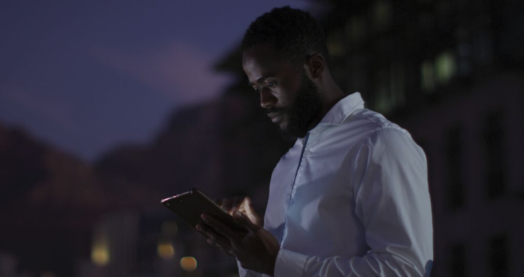 Thoughtful Businessman Using Tablet on Night Office Terrace