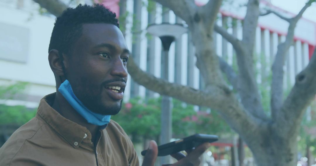 Man Communicating with Smartphone Outdoors in Urban Environment
