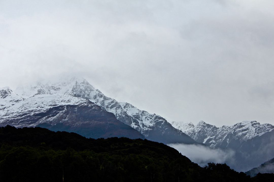 Snow-covered mountain peaks under cloudy sky - Free Images, Stock Photos and Pictures on Pikwizard.com