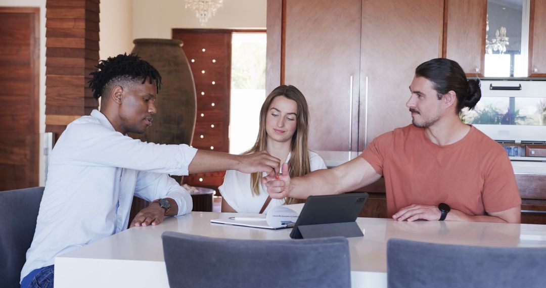 Diverse Team Collaborating On Project at Home with Tablet