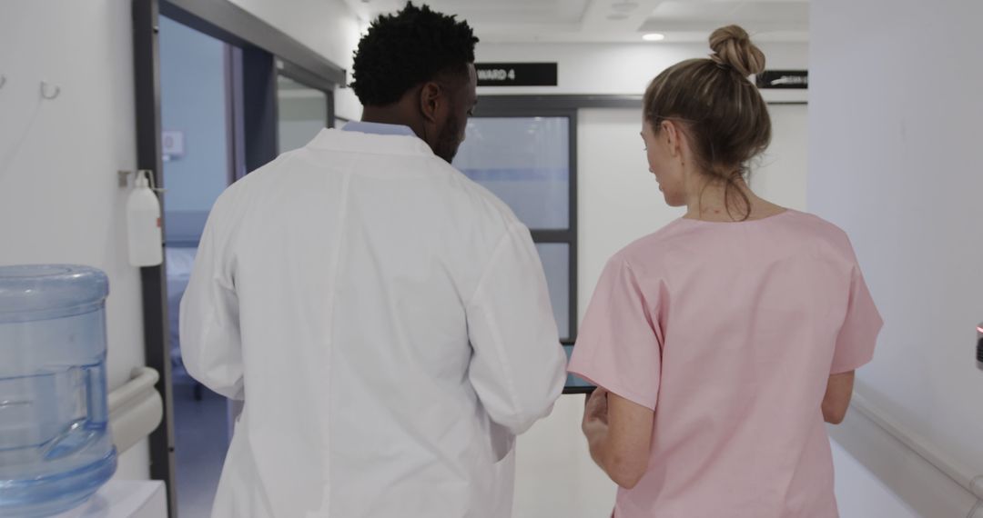 Diverse Male And Female Doctors Using Tablet In Hospital Corridor - Free Images, Stock Photos and Pictures on Pikwizard.com