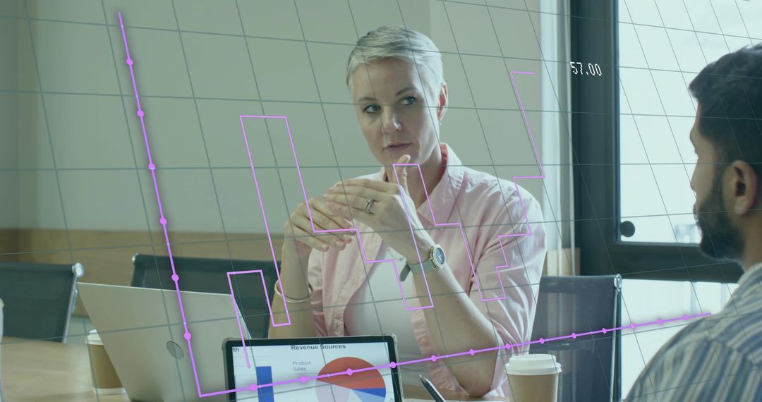 Business Professionals Analyzing Data With Digital Chart Overlay in Modern Meeting