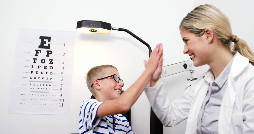 Optometrist High-Fiving Young Boy During Eye Exam - Free Images, Stock Photos and Pictures on Pikwizard.com