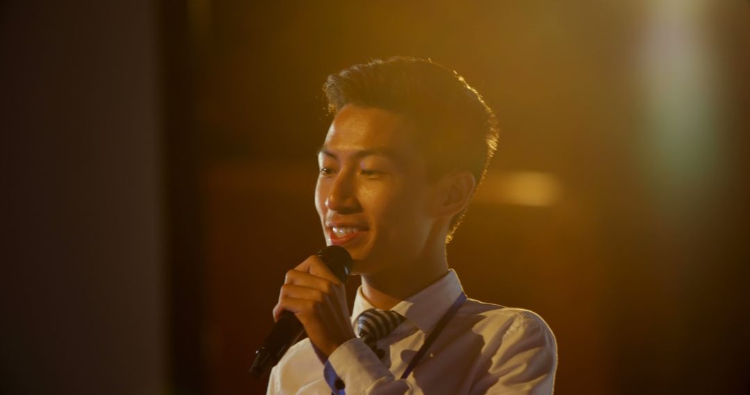 Confident Businessman Speaking in Seminar with Microphone