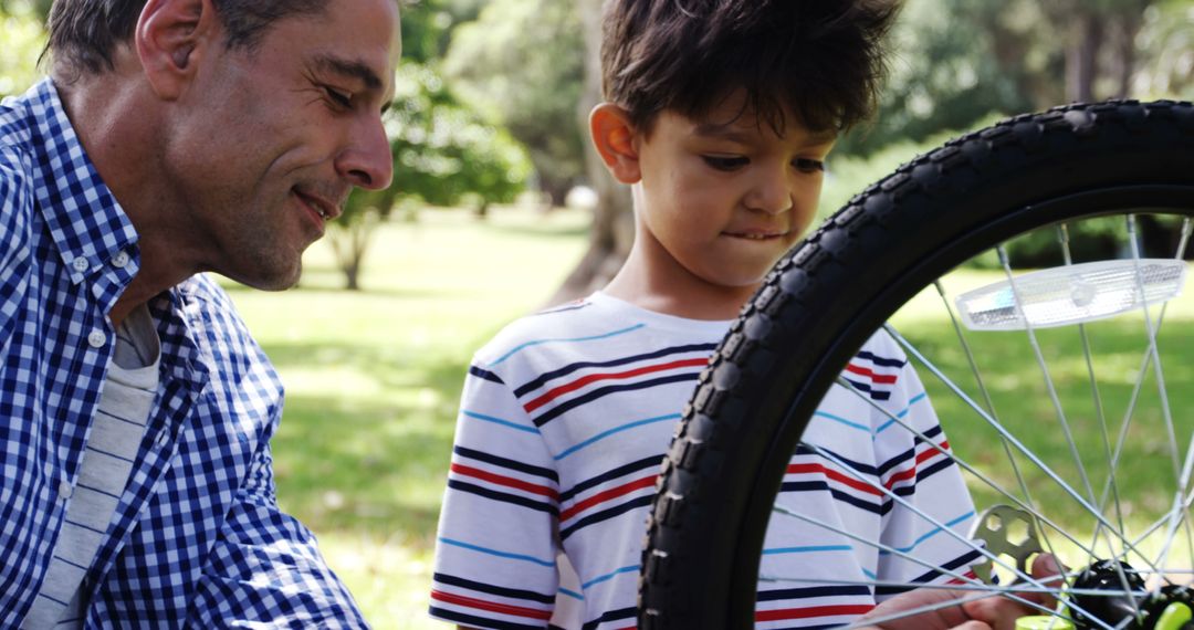 Father and Son Repairing Bicycle in Park on Sunny Day - Free Images, Stock Photos and Pictures on Pikwizard.com