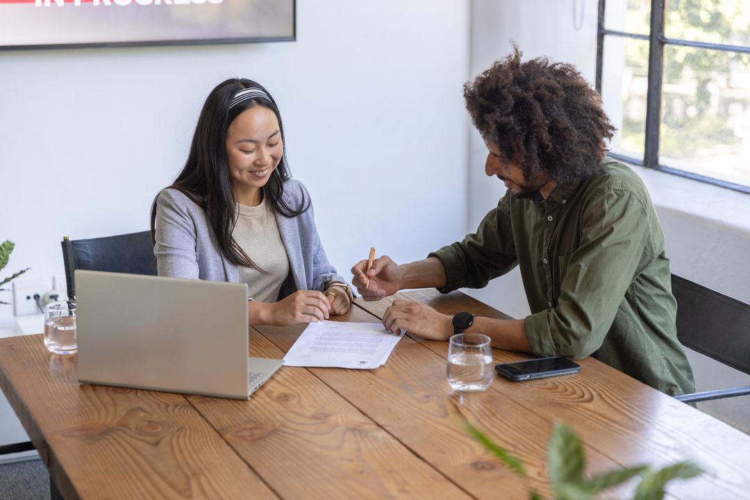 Co-workers Collaborating on Document in Office Environment