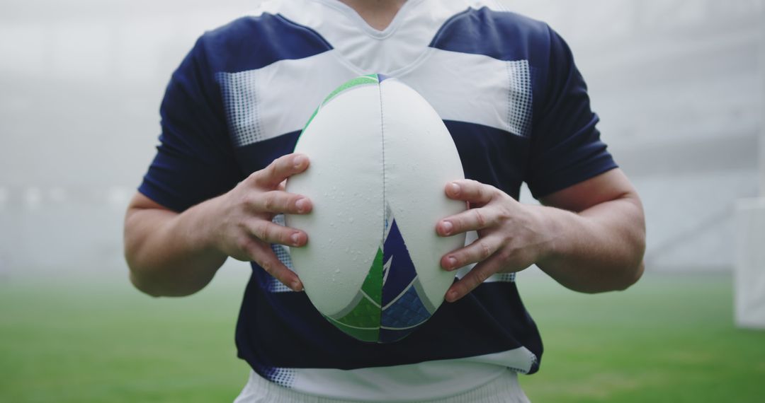 Rugby player holding ball in stadium with foggy background - Free Images, Stock Photos and Pictures on Pikwizard.com