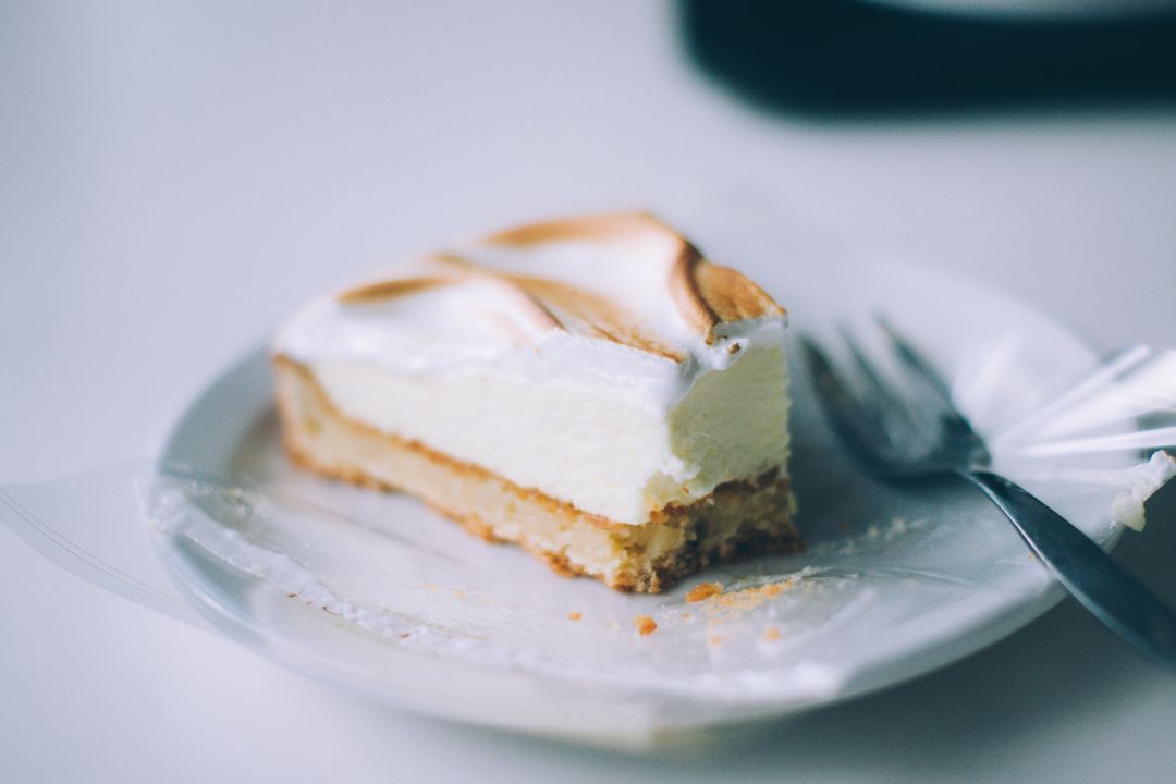 Delicious slice of lemon cheesecake on plate with fork