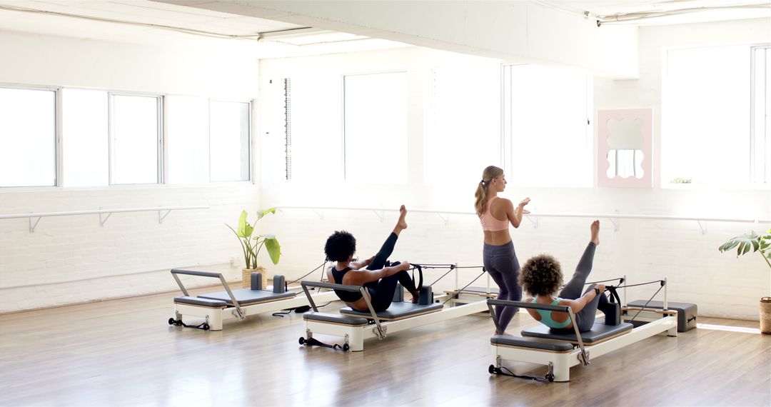 Women Practicing Pilates in Bright Studio