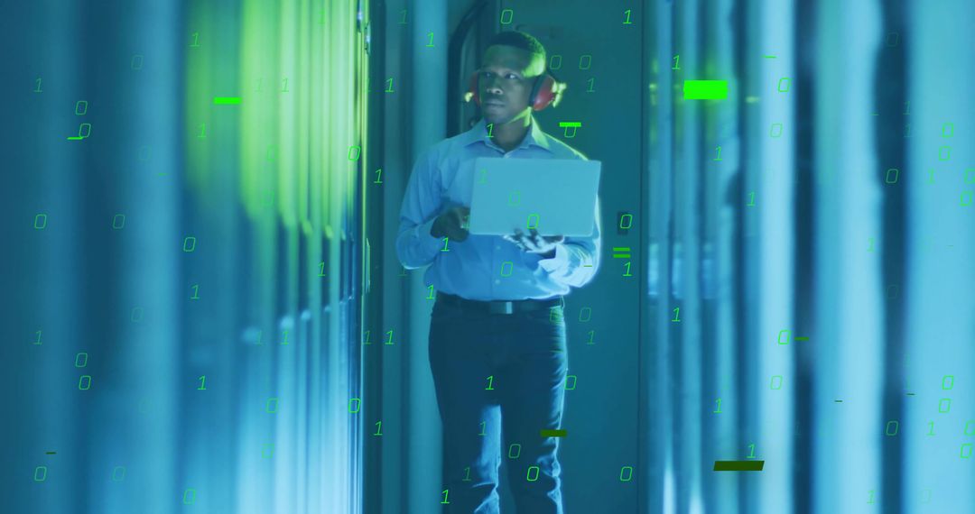 Engineer in Data Center Monitoring Racks with Laptop