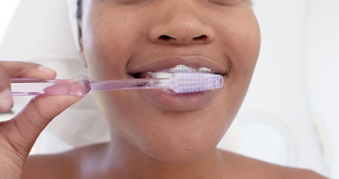 Close-Up of Woman Brushing Teeth with Transparent Toothbrush - Free Images, Stock Photos and Pictures on Pikwizard.com