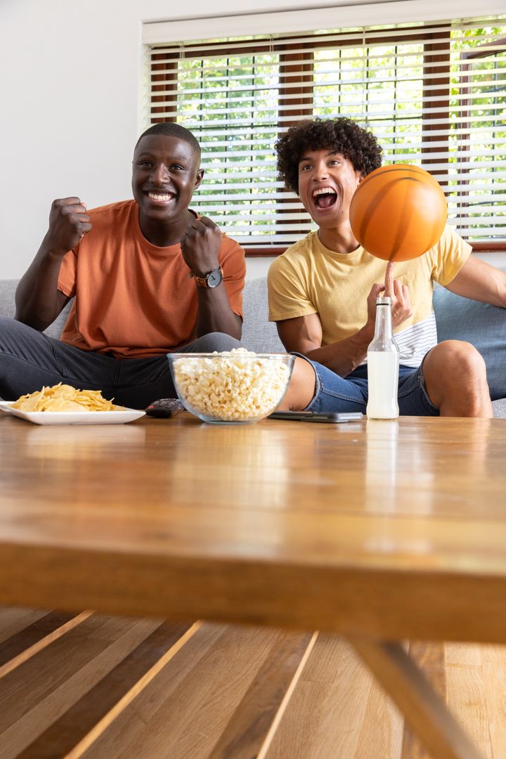 Excited Friends Watching Game at Home with Snacks