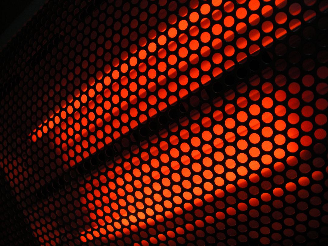 Glowing Red Perforated Metal Panel with Diagonal Light Pattern