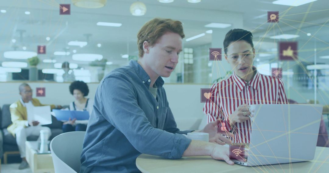 Colleagues Collaborating in Modern Office Lounge with Laptop