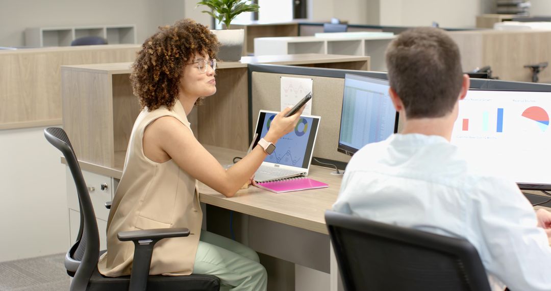 Coworkers Collaborating in Modern Office Using Smartphone and Laptop