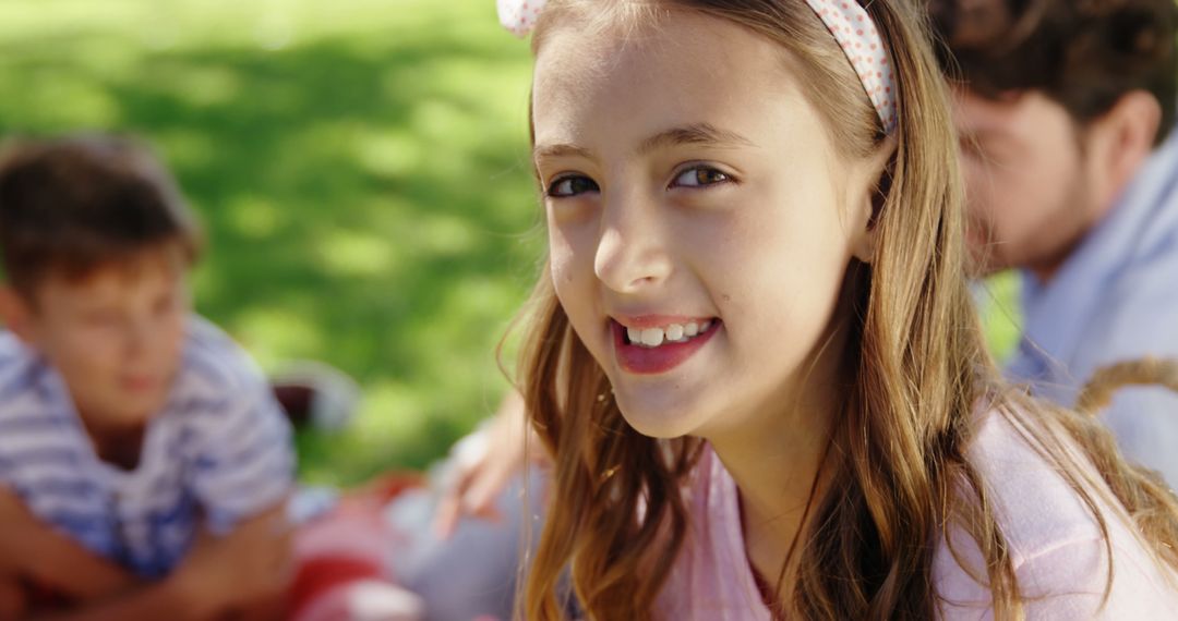 Smiling Girl Enjoying Sunny Outdoor Family Gathering - Free Images, Stock Photos and Pictures on Pikwizard.com