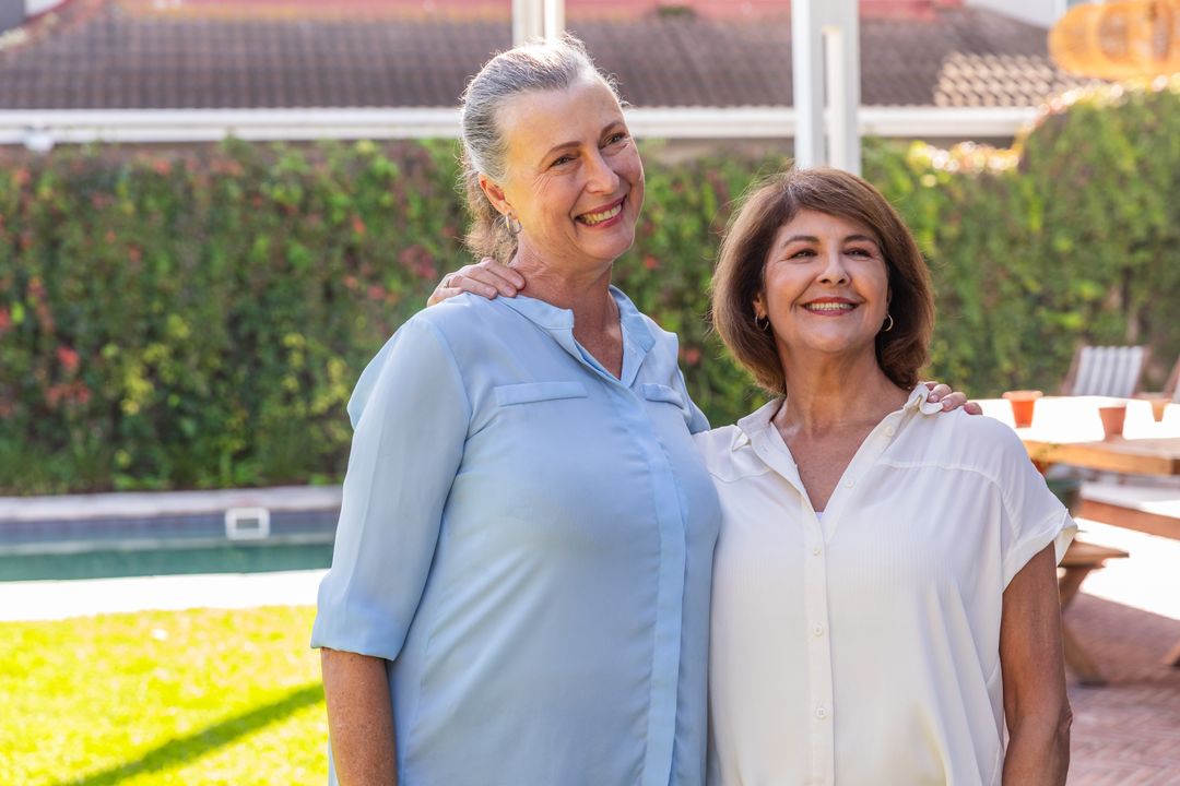 Senior Friends Smiling Outdoors Near Pool and Picnic Table