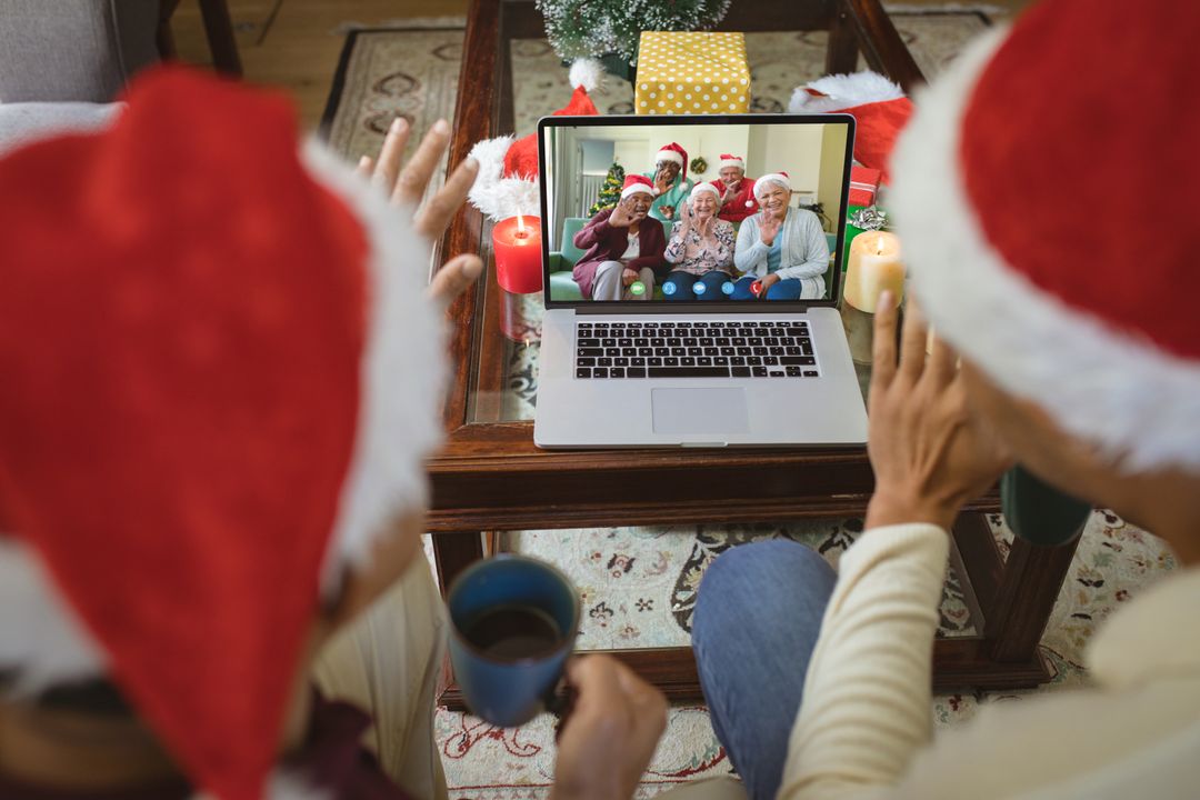 Diverse Couple Video Calling Seniors with Santa Hats during Christmas Celebration - Free Images, Stock Photos and Pictures on Pikwizard.com